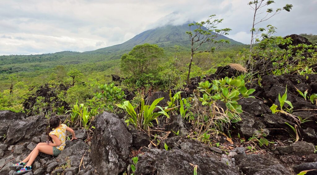 Girl sitting on dried lava from the 1968 Arenal Volcano Eruption