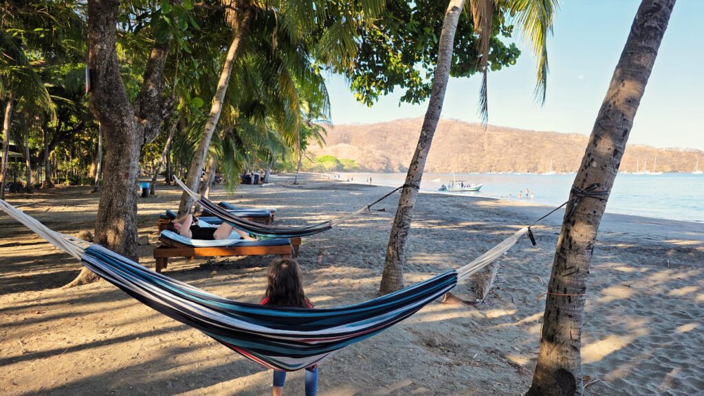 Costa Rica Itinerary with Kids - Kid swinging on hammock at Playa Hermosa in Guanacaste, Costa Rica